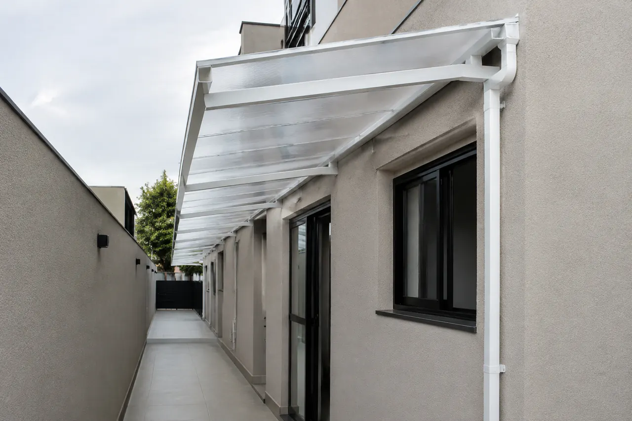 Toldo de policarbonato cobrindo corredor lateral residencial em Londrina